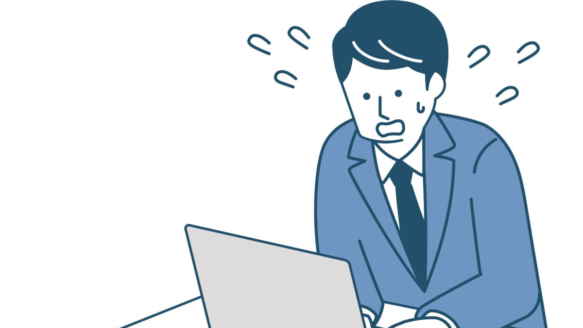 パソコン作業に焦るスーツ姿の男性のイラスト